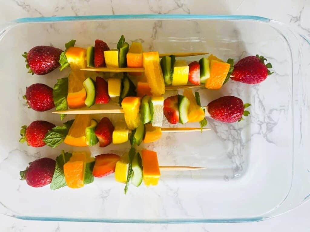 Pimms half and half fruit skewers in a dish