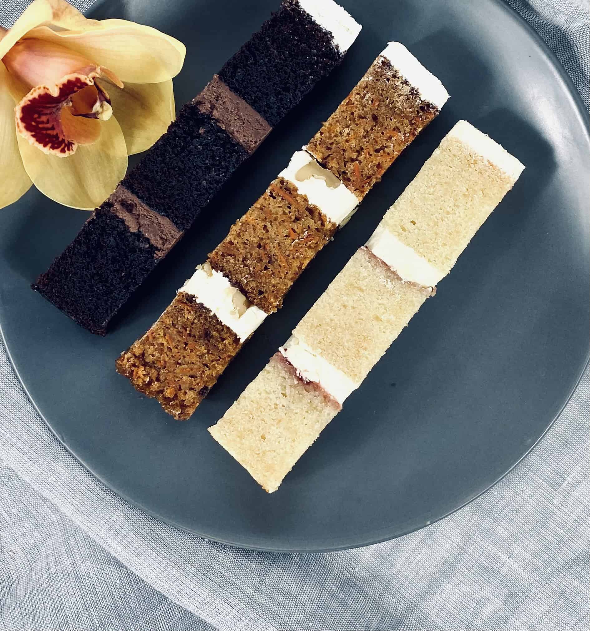 a plate with slices of chocolate, carrot and vanilla cake