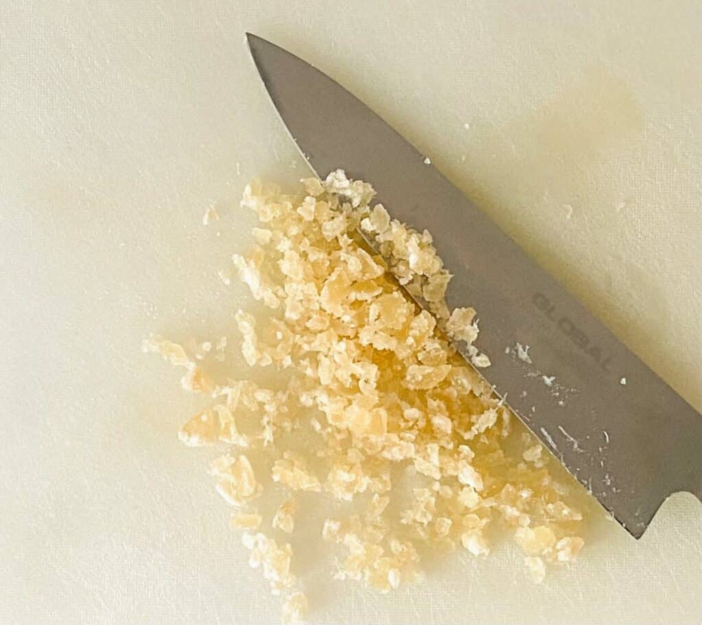 Ginger scones recipe. Crystallized ginger on a chopping board with a large knife