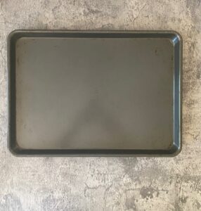 A baking tray sits on a concrete bench top
