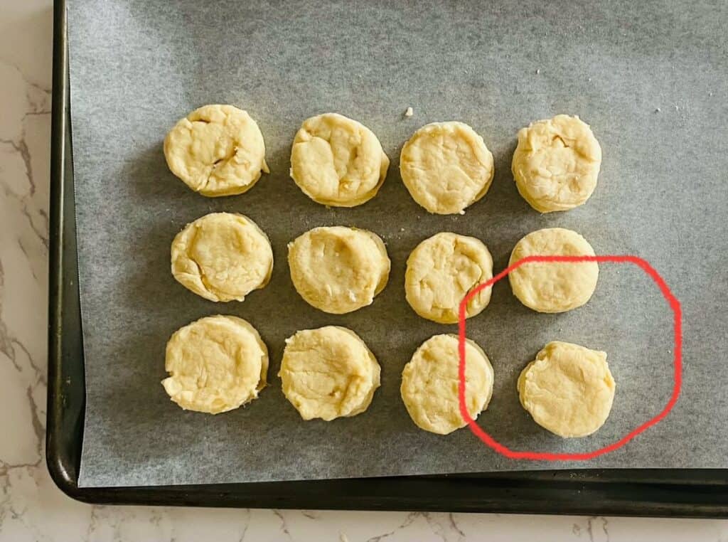 twelve scones sit on a lined baking tray
