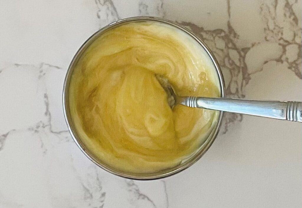 Honey Dijon sauce ingredients in a bowl ready to be mixed together and served with Chicken Wellington Sausage Rolls