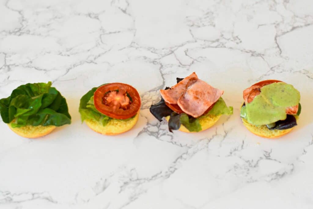 BLT sliders with green goddess dressing in varying stages of assembly