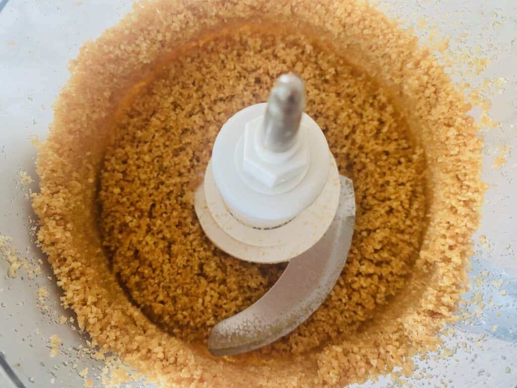 biscuit base ingredients for raspberry white chocolate cheesecake in a food processor