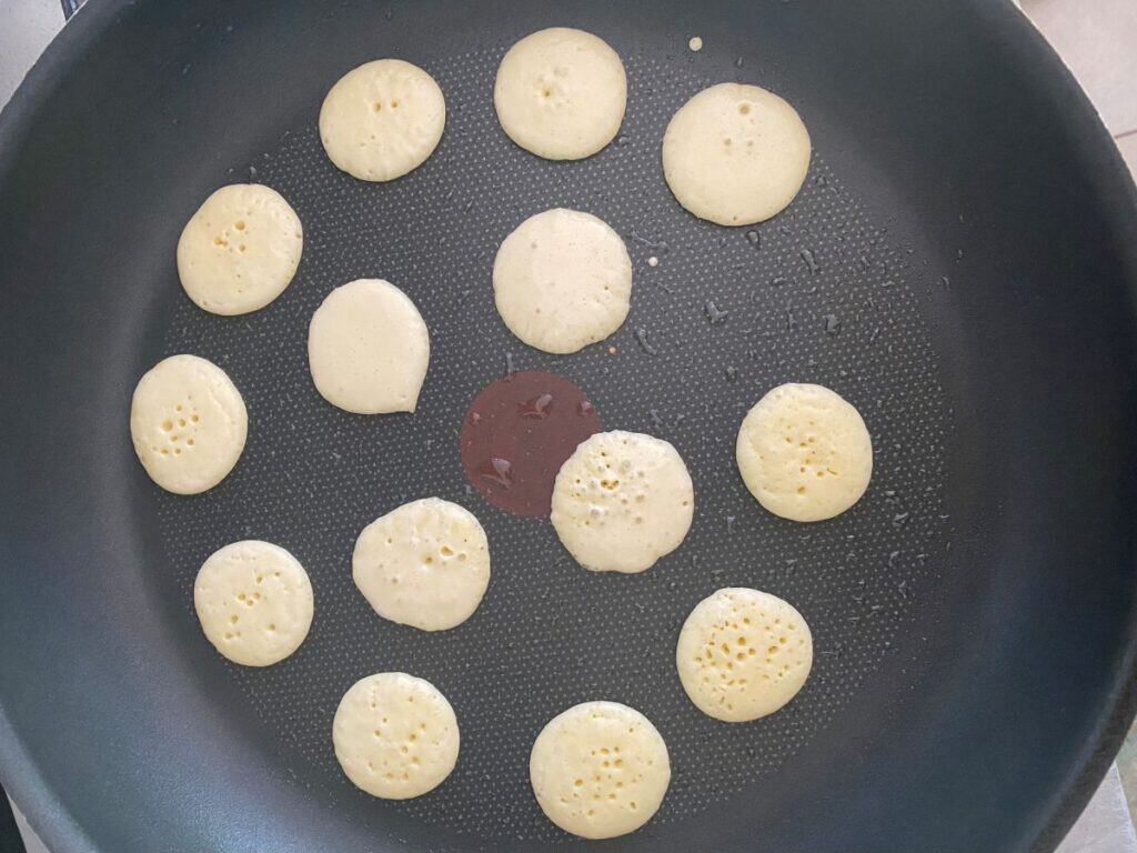 Smoked salmon pikelets cooking in a frying pan