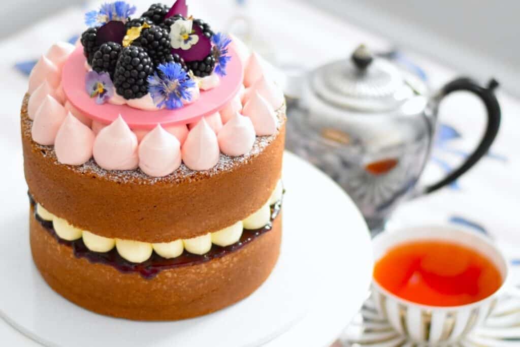 Lemon blackberry sandwich cake with a tea cup and teapot