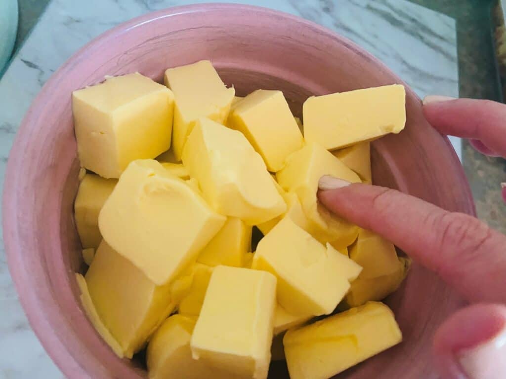 Softened butter in a pink bowl for Swiss Meringue Buttercream