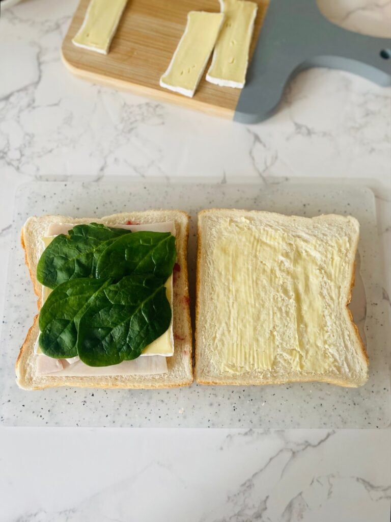 Turkey, cranberry & brie finger sandwiches preparation - add the baby spinach