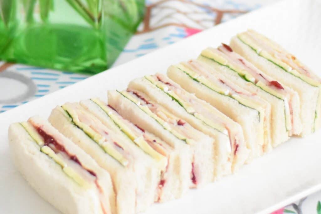 Turkey, cranberry & brie finger sandwiches on a plate ready to serve