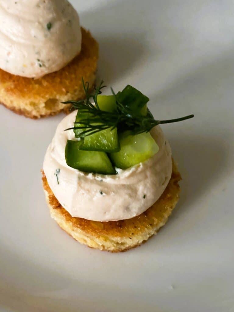 Salmon cucumber brioche bites topped with cucumber and garnished with dill