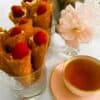 Brandy snap cones in glasses with a cup of tea