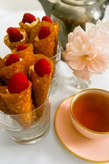 Brandy snap cones in glasses with a cup of tea