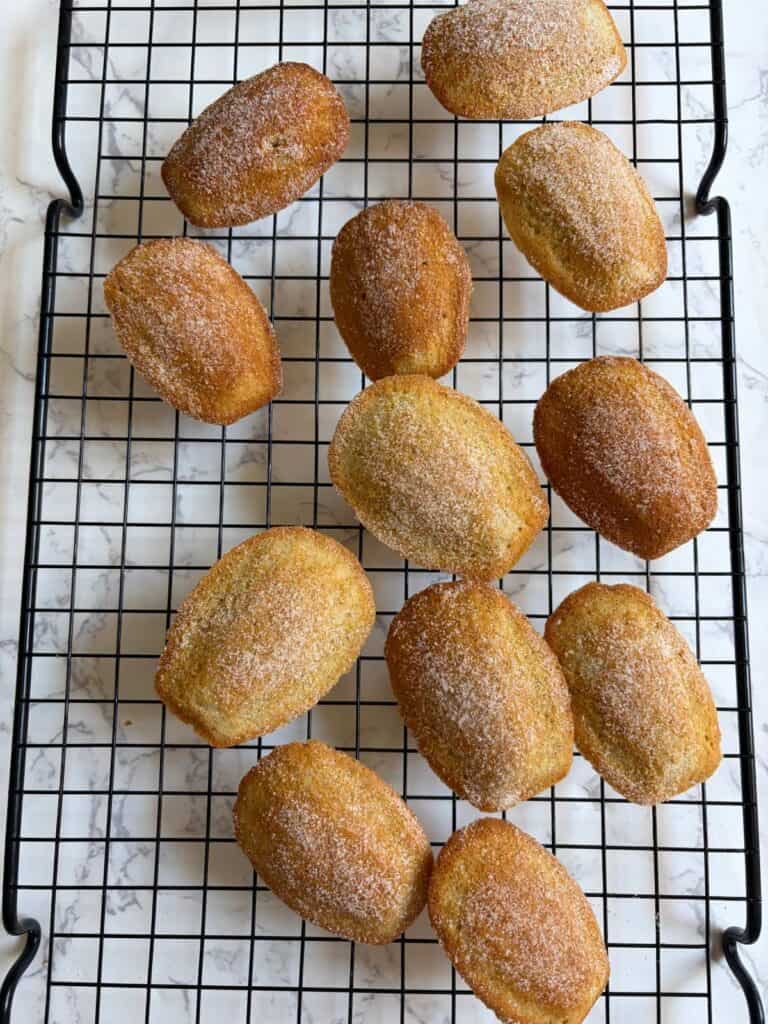 Cinnamon roll madeleines on a wire rack