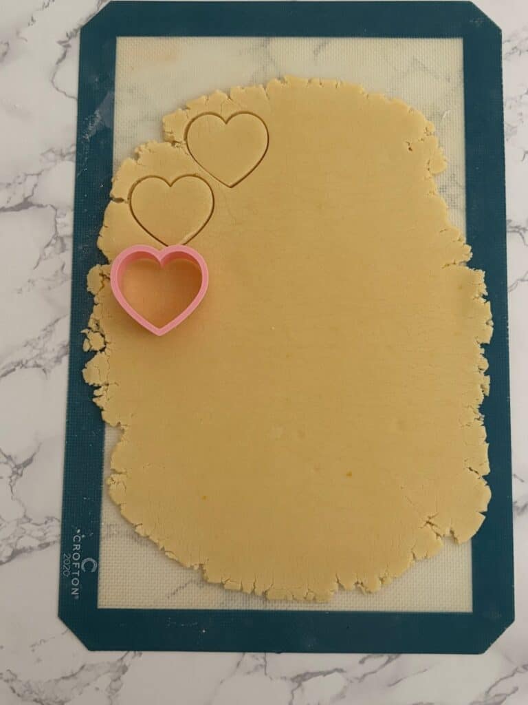 Heart cutter and dough on a silicone mat