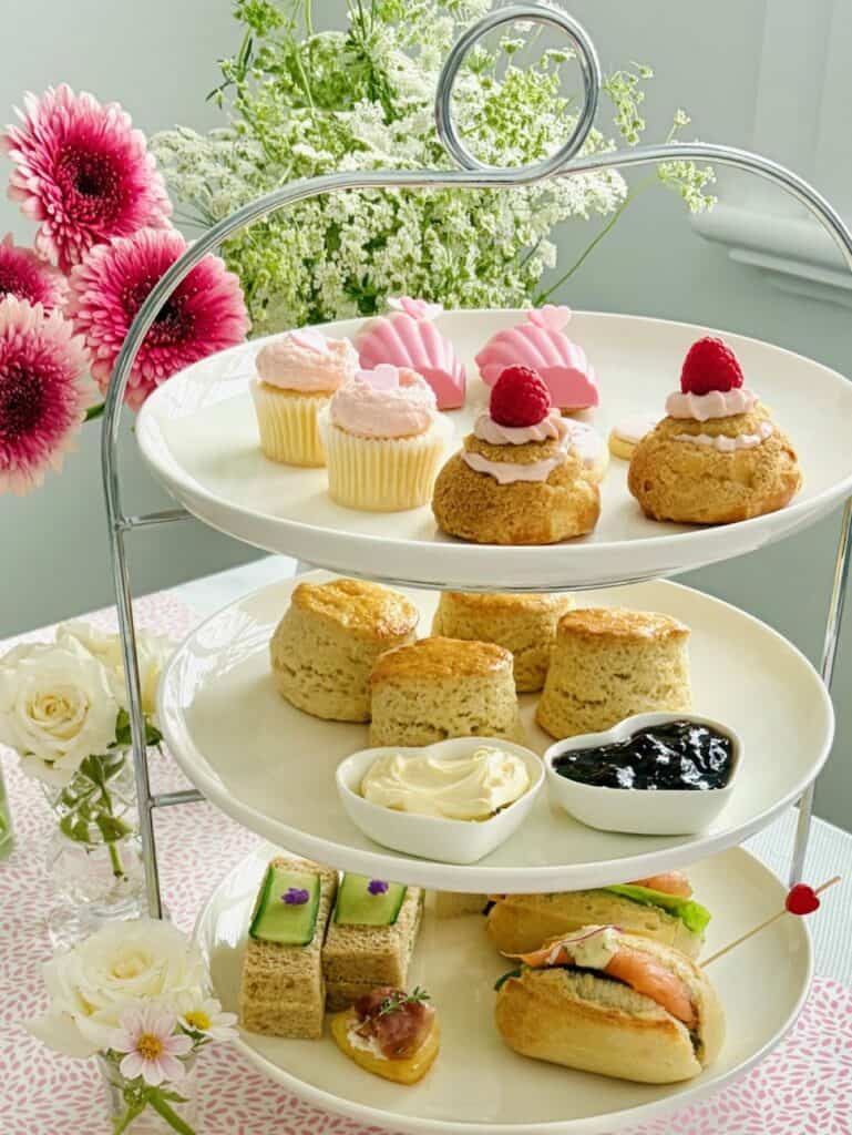 A tiered afternoon tea stand featuring sweets, scones and savouries.