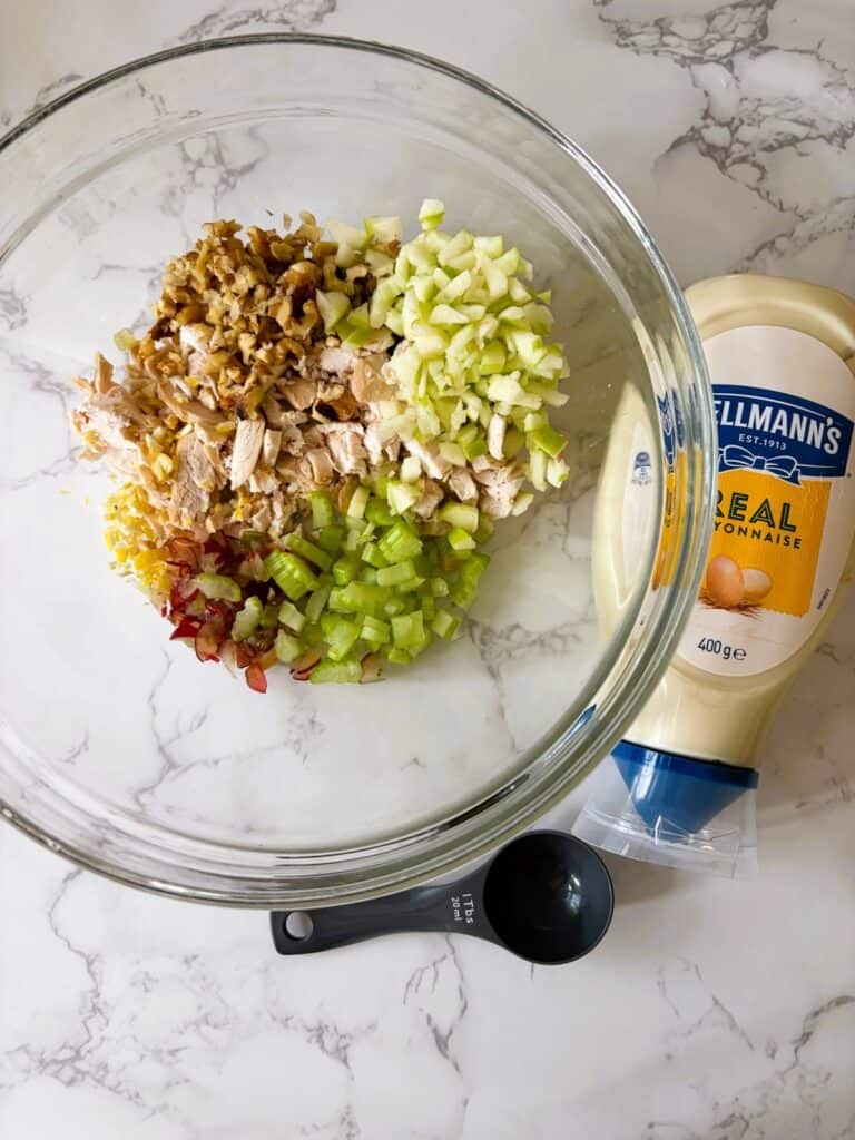 Finely chopped Chicken Waldorf Finger sandwich ingredients in a bowl with mayonnaise on the side