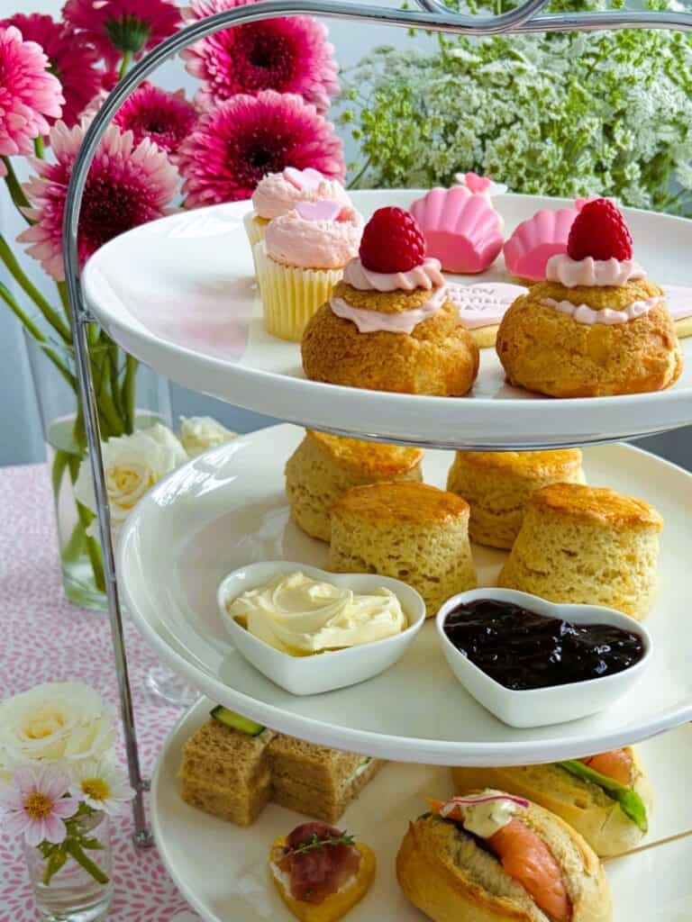 Raspberry cheesecake choux puffs on a tiered afternoon tea stand