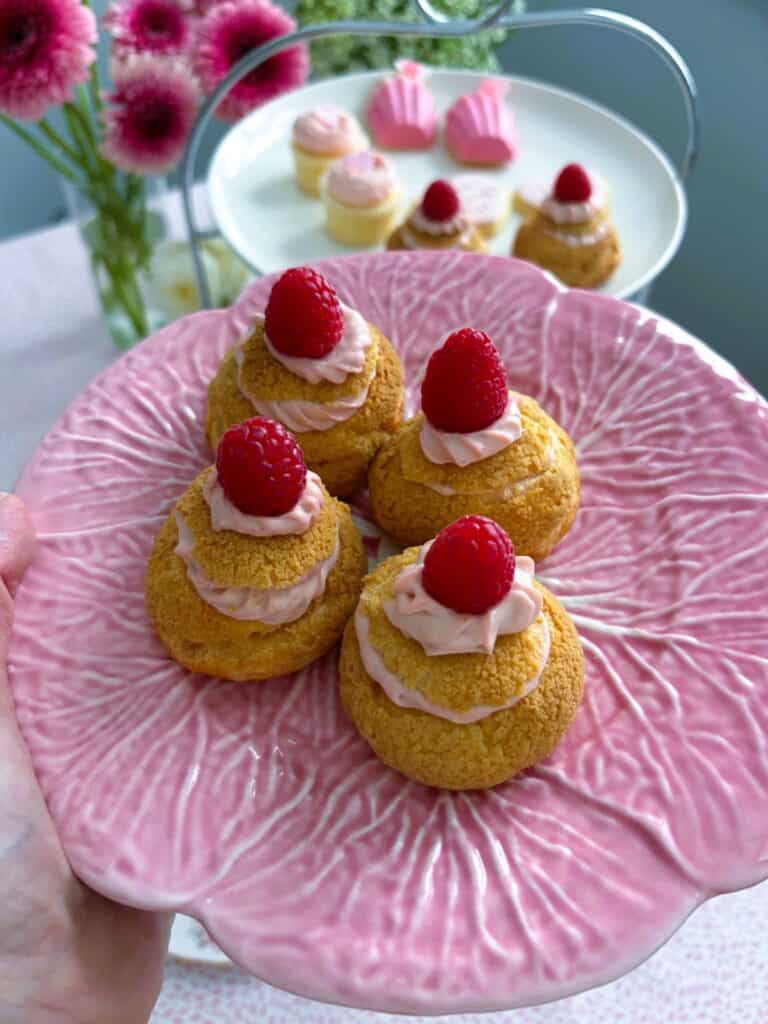 raspberry cheesecake choux puffs on a pink plate