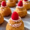 Raspberry cheesecake choux puffs in a row