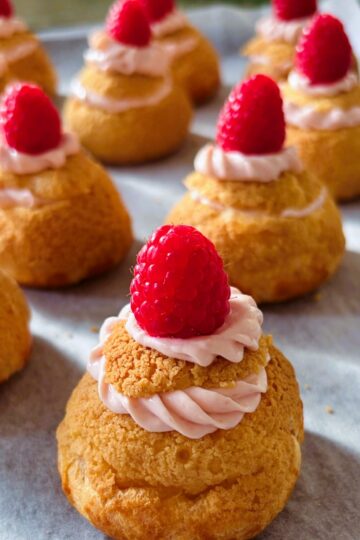 Raspberry cheesecake choux puffs in a row