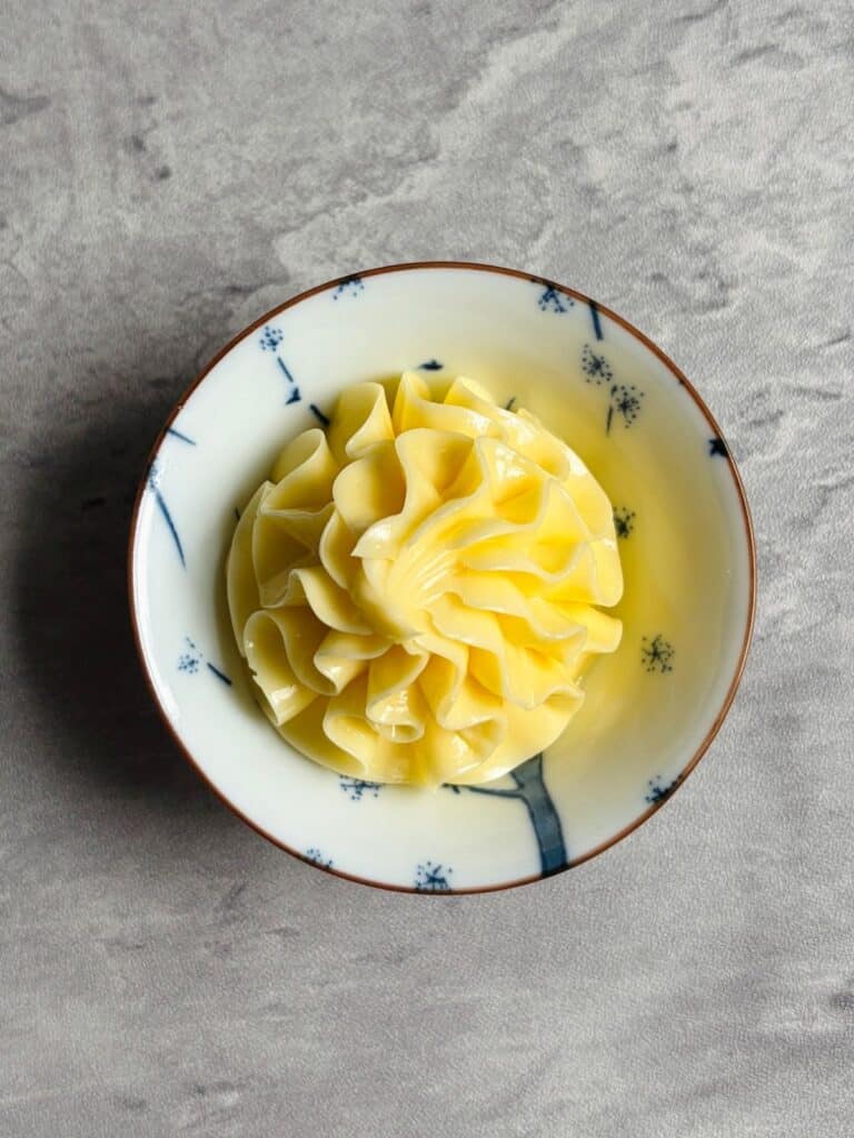 piped honey butter in a blue and whie bowl