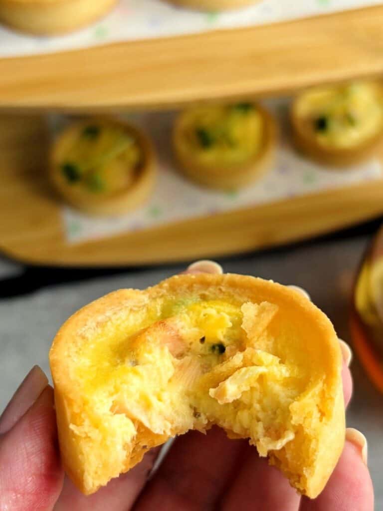 Salmon, pea & parmesan tartlet with a bite taken out of it