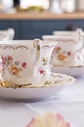Delicate floral china cups elegantly set up for a tea party. Perfect for showcasing vintage charm.