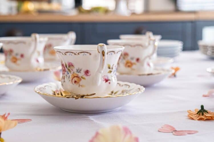 Delicate floral china cups elegantly set up for a tea party. Perfect for showcasing vintage charm.