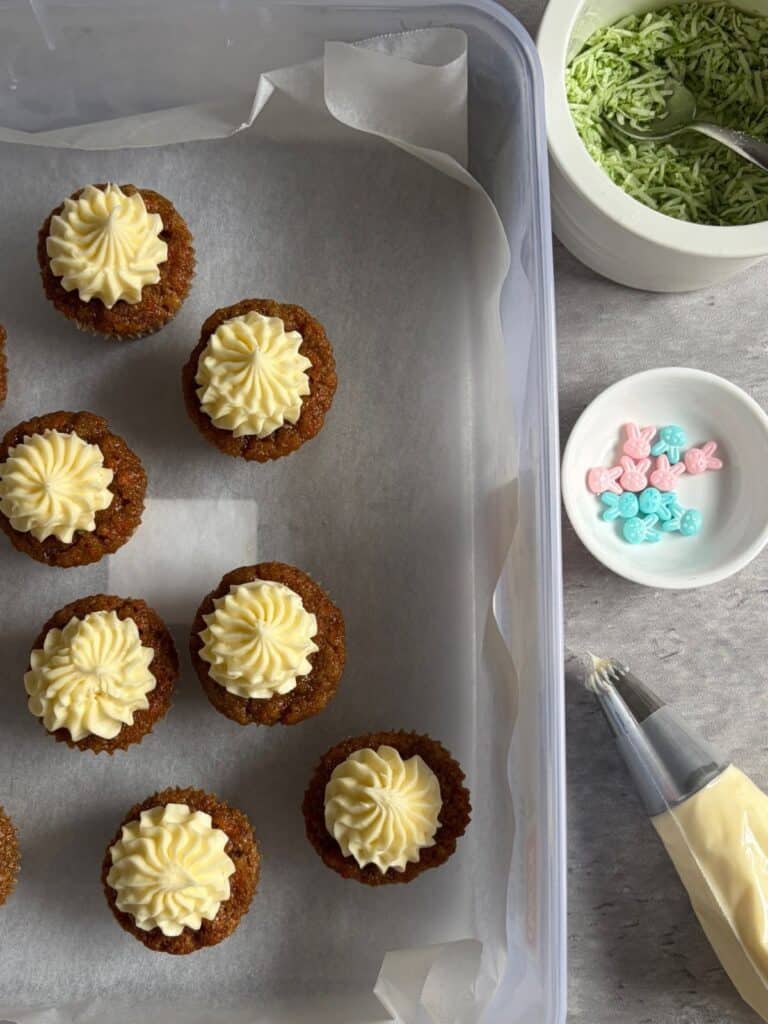 Lemon cream cheese icing piped on top of mini carrot cakes